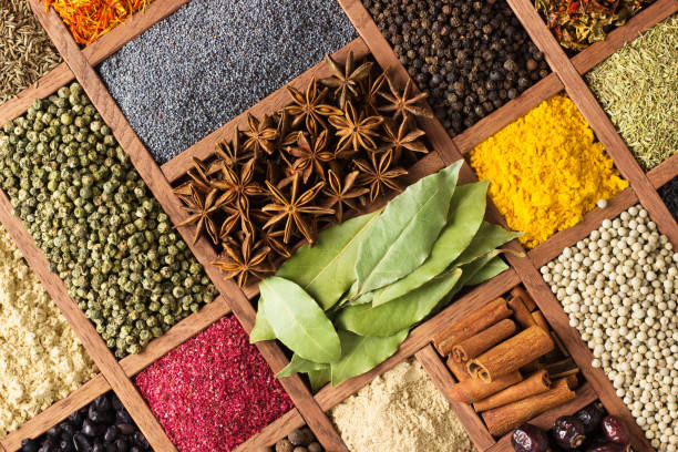 lumineux herbes et épices dans des bacs en bois sur la vitrine. set d’assaisonnement pour la cuisine, dans la boîte avec les cellules. - cardamom herb green spice photos et images de collection