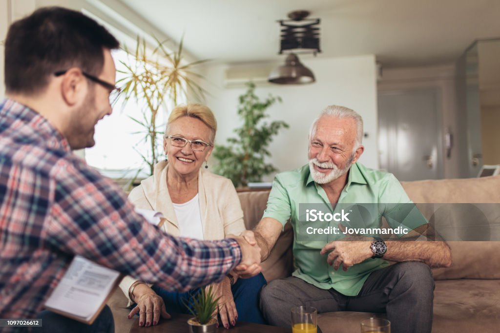 Positive aged couple consulting with insurance agent Senior Adult Stock Photo