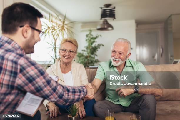Positive Aged Couple Consulting With Insurance Agent Stock Photo - Download Image Now