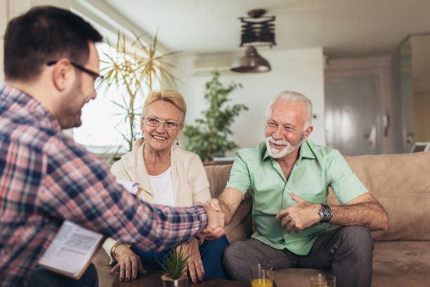 positive aged couple consulting with insurance agent - inheritance tax imagens e fotografias de stock