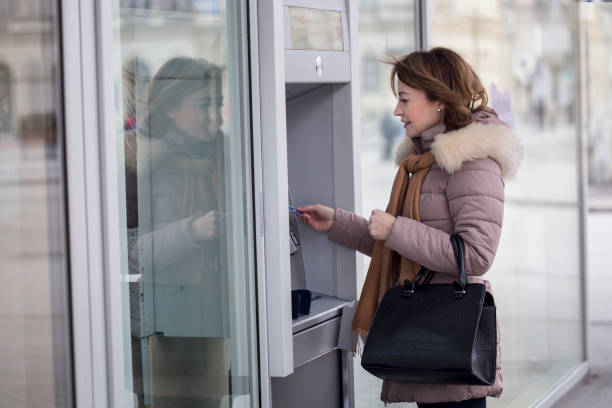 istock Adult woman using an ATM 1097026954