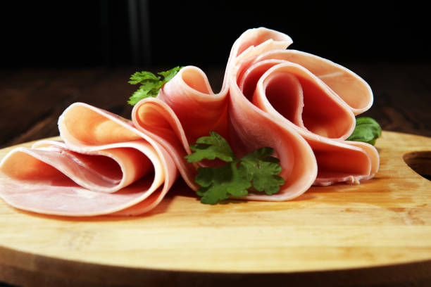 istock Sliced ham with parsley on table. Fresh prosciutto. Pork ham sliced. 1097031846