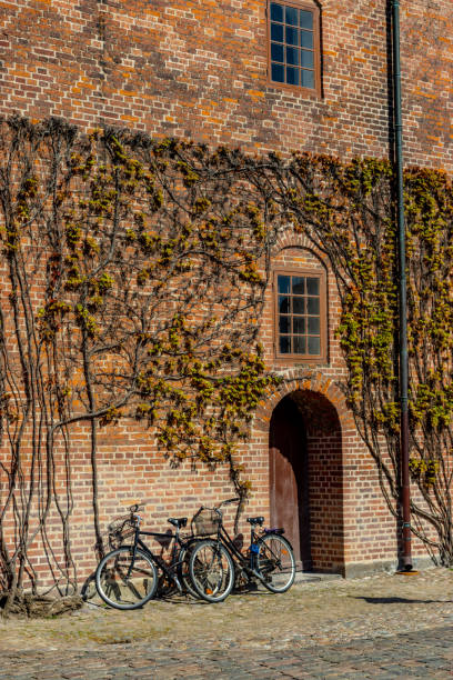 White window with Curtain and retro bicycles in the Dutch City. Bikes leaning against the red brick wall in Amersfoort. Vintage style toned picture