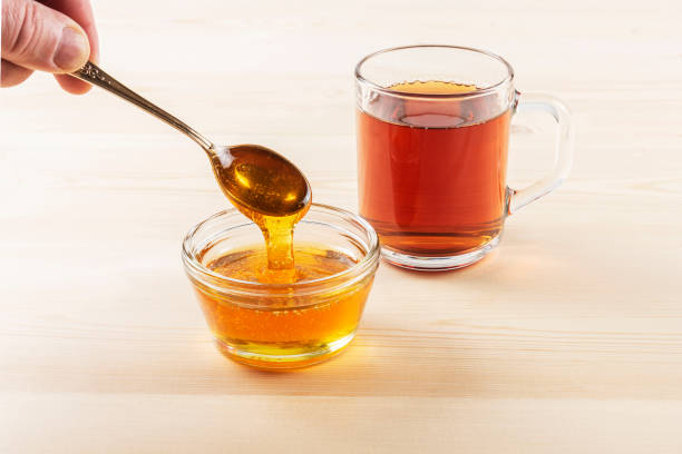 istock Honey in a jar on a wooden background 1097059580