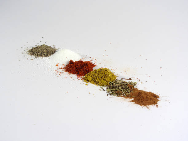 Spices Various ground spices, including black pepper, paprika, salt, nutmeg, cinnamon, curry and origano, arranged in a row on white. majoran stock pictures, royalty-free photos & images