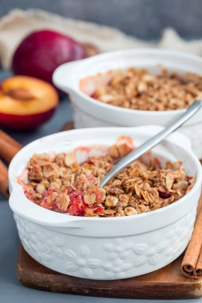 istock Plum crumble pie or plum crisp with oats and spices, in baking dish, vertical 1097080446