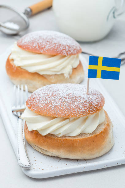 istock Traditional swedish dessert Semla, also called Shrove bun, with almond paste and whipped cream filling, served with milk, vertical 1097080554