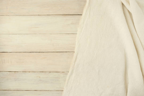 istock Beige woven textile drape on wooden  background. 1097081410