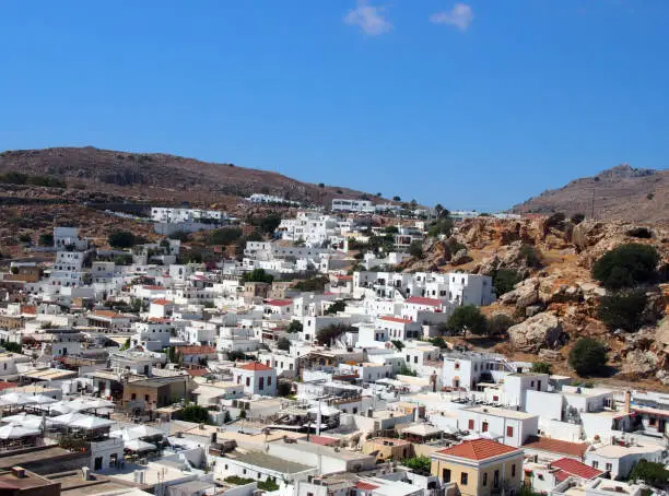 an arial panoramic view of afandou village in rhodes with blue sky and mountains