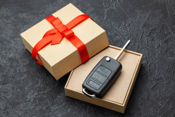 istock Gift box with car keys with remote control alarm system with red ribbon bow. 1097092596