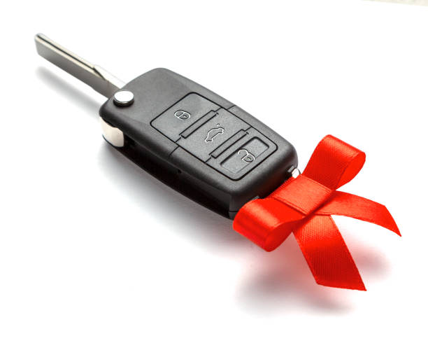 istock Gift Car keys with remote control alarm with red ribbon with bow. Isolated on white background. 1097092890