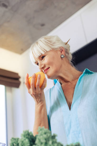 istock Nice joyful woman smelling fresh yellow pepper 1097093306