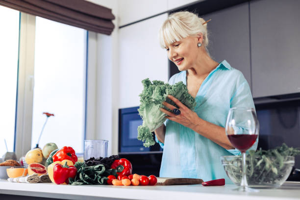 istock Pleasant nice woman holding green lettuce in her hands 1097093312