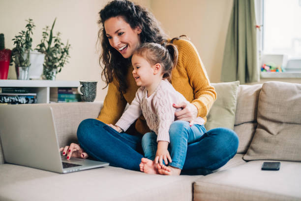 istock Mother and daughter using laptop on sofa 1097093650