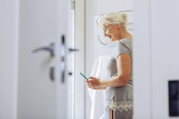 istock Joyful nice aged woman typing a message 1097094850
