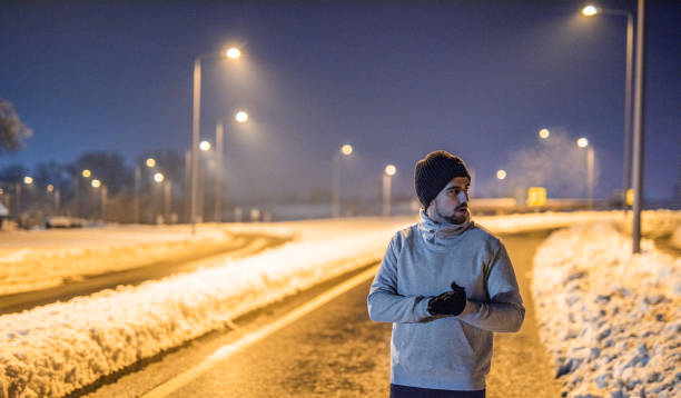 istock Sporty young man preparing for exercise on a cold winter night. 1097096138
