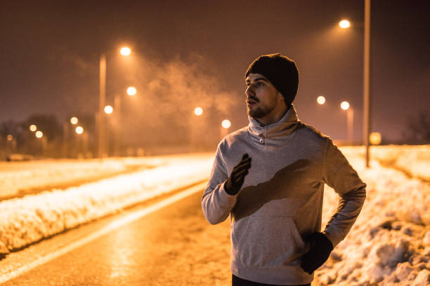 istock Young man running in the city on a cold winter night. 1097098548