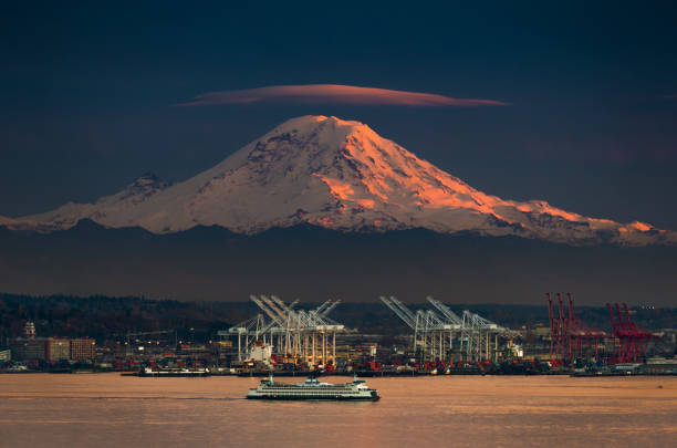Night Cap Lenticular cloud caps Mt. Rainier as seen from West Seattle with ferry in foreground. ferry photos stock pictures, royalty-free photos & images