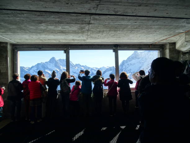 Worth seeing view At the window of the Eiger Nordwand stop of the Jungfraujochbahn, passengers crowd for a quick glance and a photo before continuing their journey. eiger northface stock pictures, royalty-free photos & images