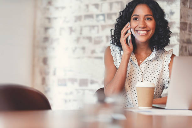 istock Attractive woman talking on a mobile phone with laptop computer. 1097113254