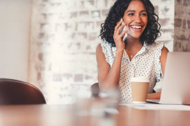 istock Attractive woman talking on a mobile phone with laptop computer. 1097113268