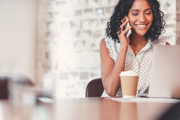 istock Attractive woman talking on a mobile phone with laptop computer 1097113276