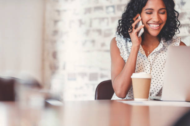 istock Attractive woman talking on a mobile phone with laptop computer. 1097113280