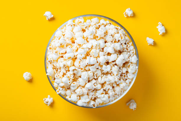 istock Glass bowl with salted popcorn on yellow background. Top view with copy space. Flat lay 1097126308
