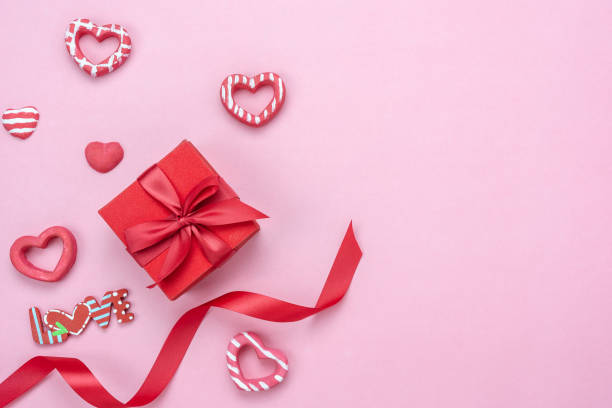 Table top view aerial image of decoration valentine's day background concept.Flat lay essential items gift box with ribbon & love season on modern pink paper.blank space for mock up creative design.