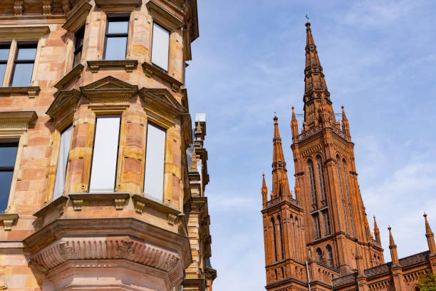 Architectural detail of the sandstone facade of the city hall in downtown Wiesbaden, Germany with Lutheran Marktkirche (Market Church) in the background.