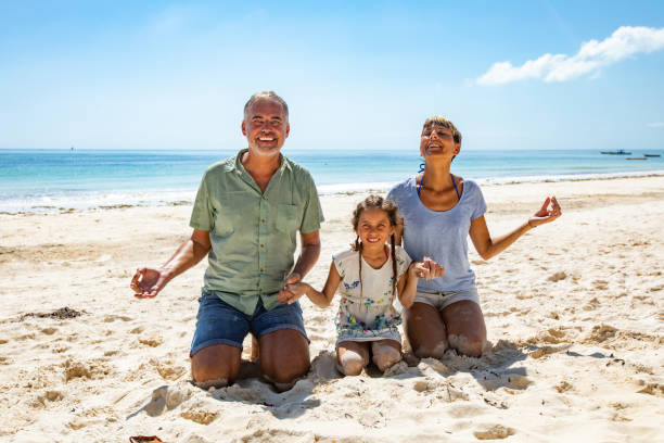 istock Smiling Family Holding Hands and Relaxing on Beach 1097136182