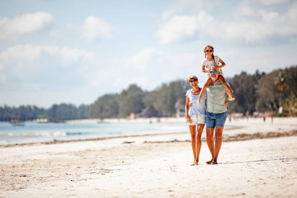 istock Family WIth One Daughter Walking on Sandy Beach 1097136408