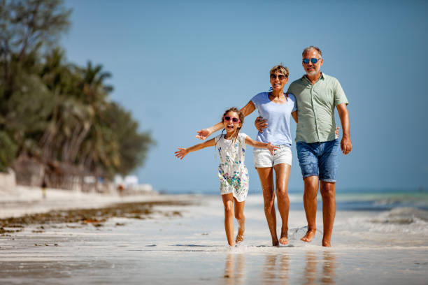 istock Family WIth One Daughter Walking on Sandy Beach 1097136470