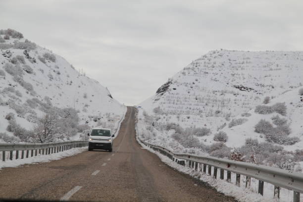 istock snowy long roads and white car 1097139352