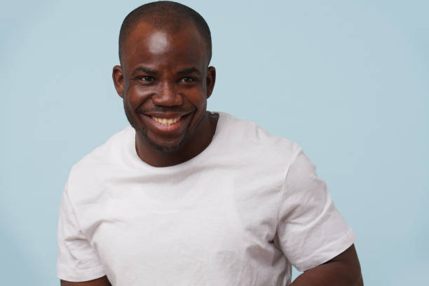 istock Handsome black man smiling, against pale blue background. 1097156172