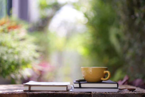 istock Yellow ceramic cup with notebooks at on wooden table 1097163088