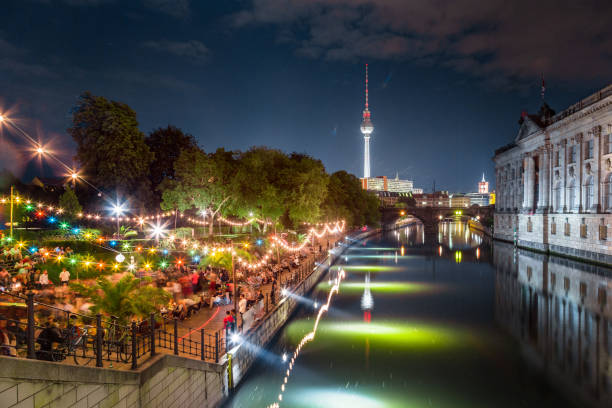 Berlin Strandbar party at Spree river with TV tower at night, Germany People dancing at summer Strandbar beach party near Spree river at Museum Island with famous TV tower in the background at night, Berlin, Germany spree river photos stock pictures, royalty-free photos & images