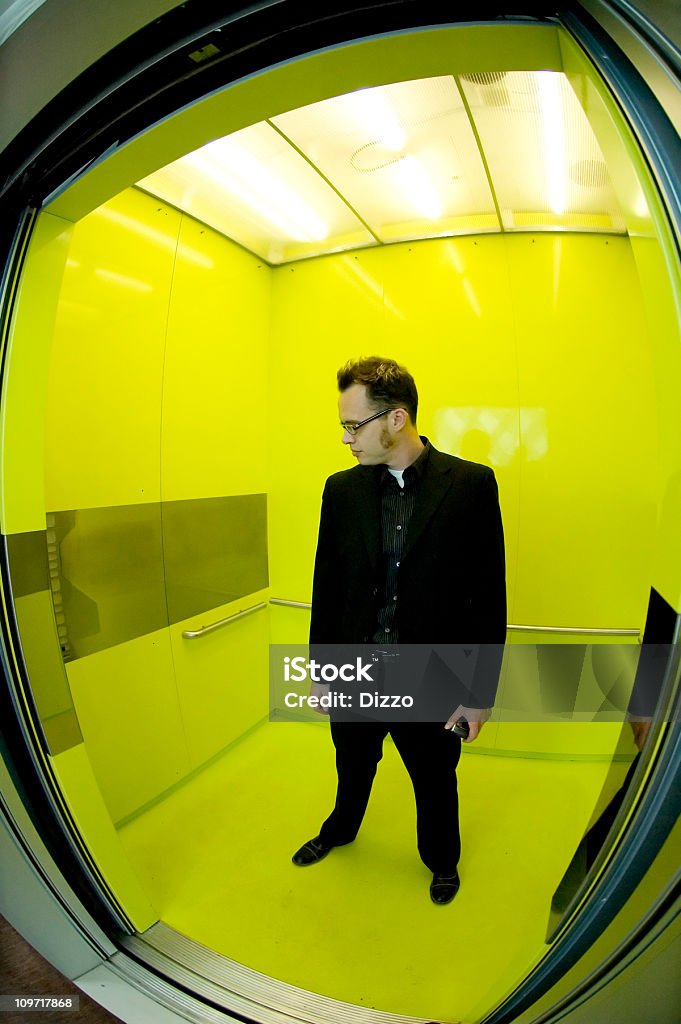 Homme debout dans un coloris vif, un ascenseur panoramique - Photo de Adulte libre de droits