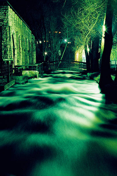 Stream Flowing Under Bridge at Night stock photo