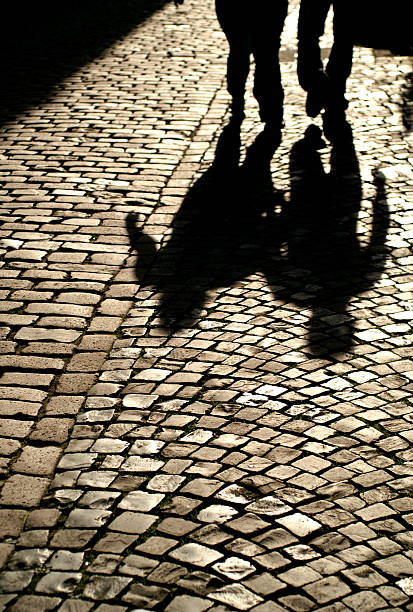 istock Two People and Their Shadows Walking Down Cobblestone Street 109717918