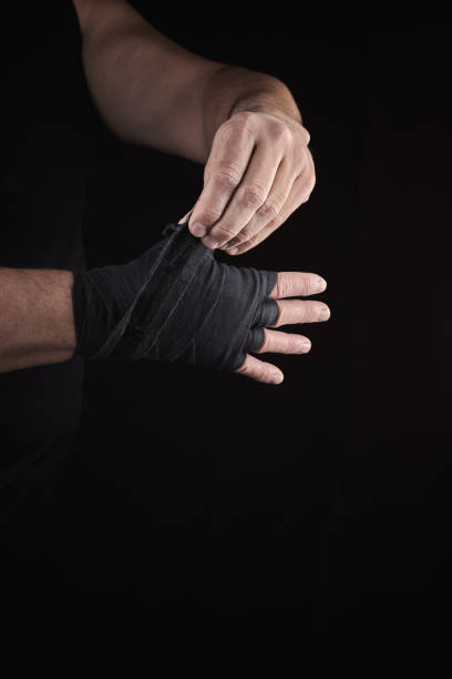 istock man wraps his hands in black textile bandage for sports 1097179558