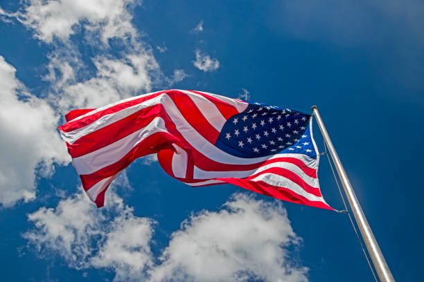 istock American Flag flying against a blue sky. 1097179626
