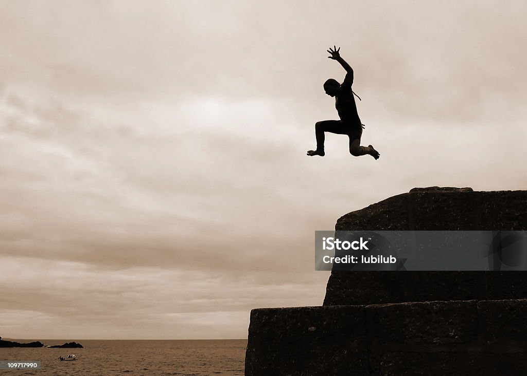 I can fly! Silhouette of Boy Cliff Diving  Cliff Jumping Stock Photo