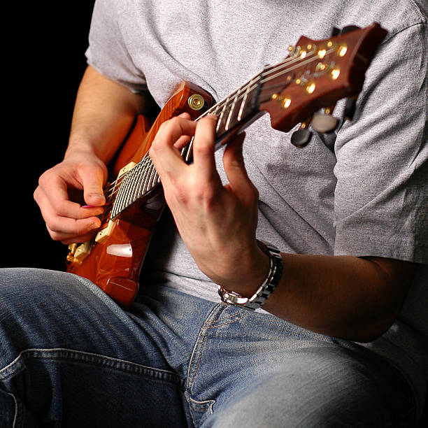 istock Man Sitting and Playing Electric Guitar, Isolated on Black 109718139