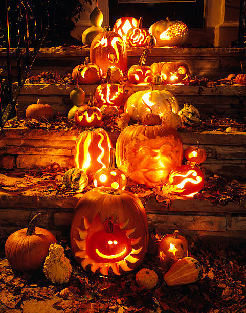 Carved Pumpkins and Autumn Leaves on Steps to House stock photo