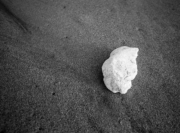 Lone Pebble on Sand Beach, Black and White stock photo