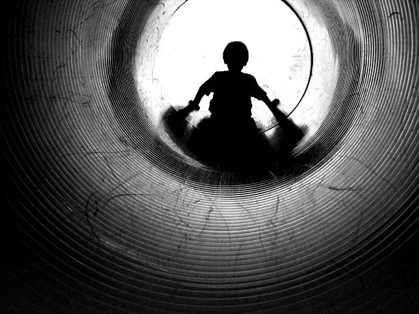 A little girl swings on a swingset as the sun drops to the horizon.