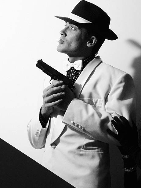 A man in black clothes, a black leather coat, hat. Ganster with a cigar. Mafiosi in black glasses on a dark background. Severe, strong, stylish, impressive, dangerous, unfriendly, evil, rude man.