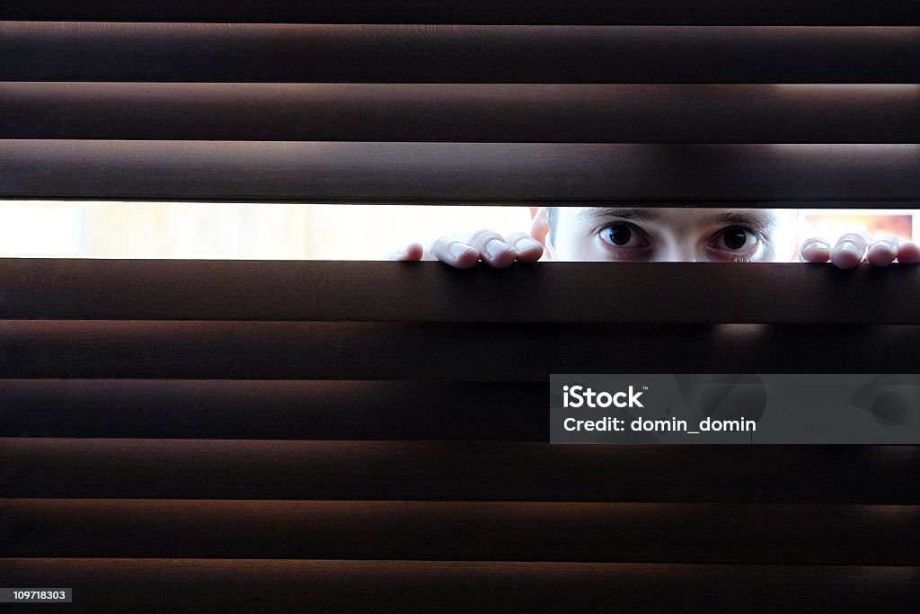 Mann ist Spionage durch Loch im Fenster's Fensterläden aus Holz - Lizenzfrei Verschwörung Stock-Foto