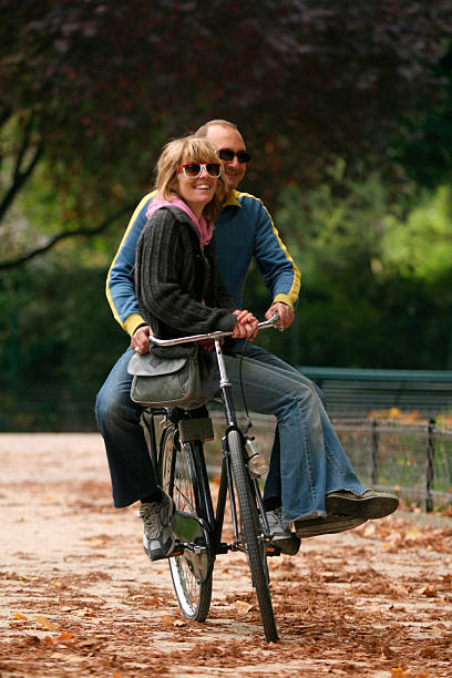 istock Couple Bicycling on Same Bike Through Park 109718484